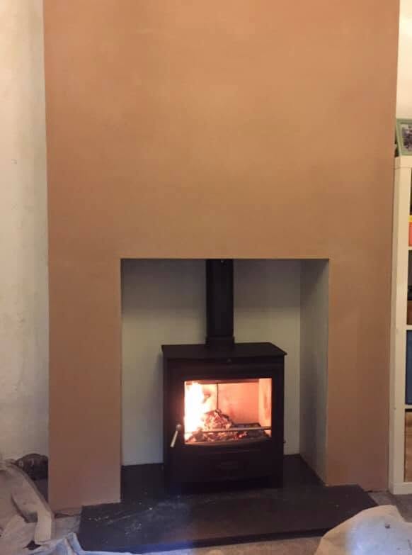 Finished stove in a clean plastered fireplace recess