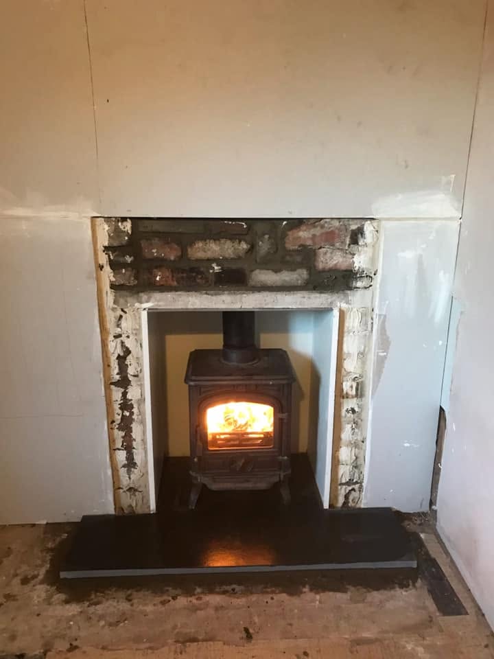 Finished stove on dark hearth after fireplace rebuild