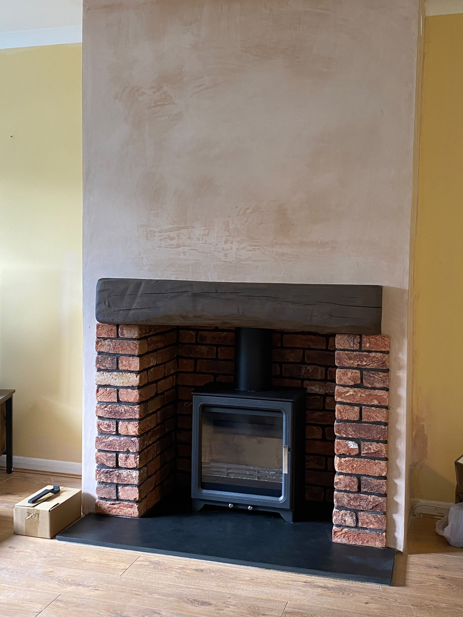 Finished bespoke chimney breast with brick slips, slate hearth, resin beam and multi-fuel stove